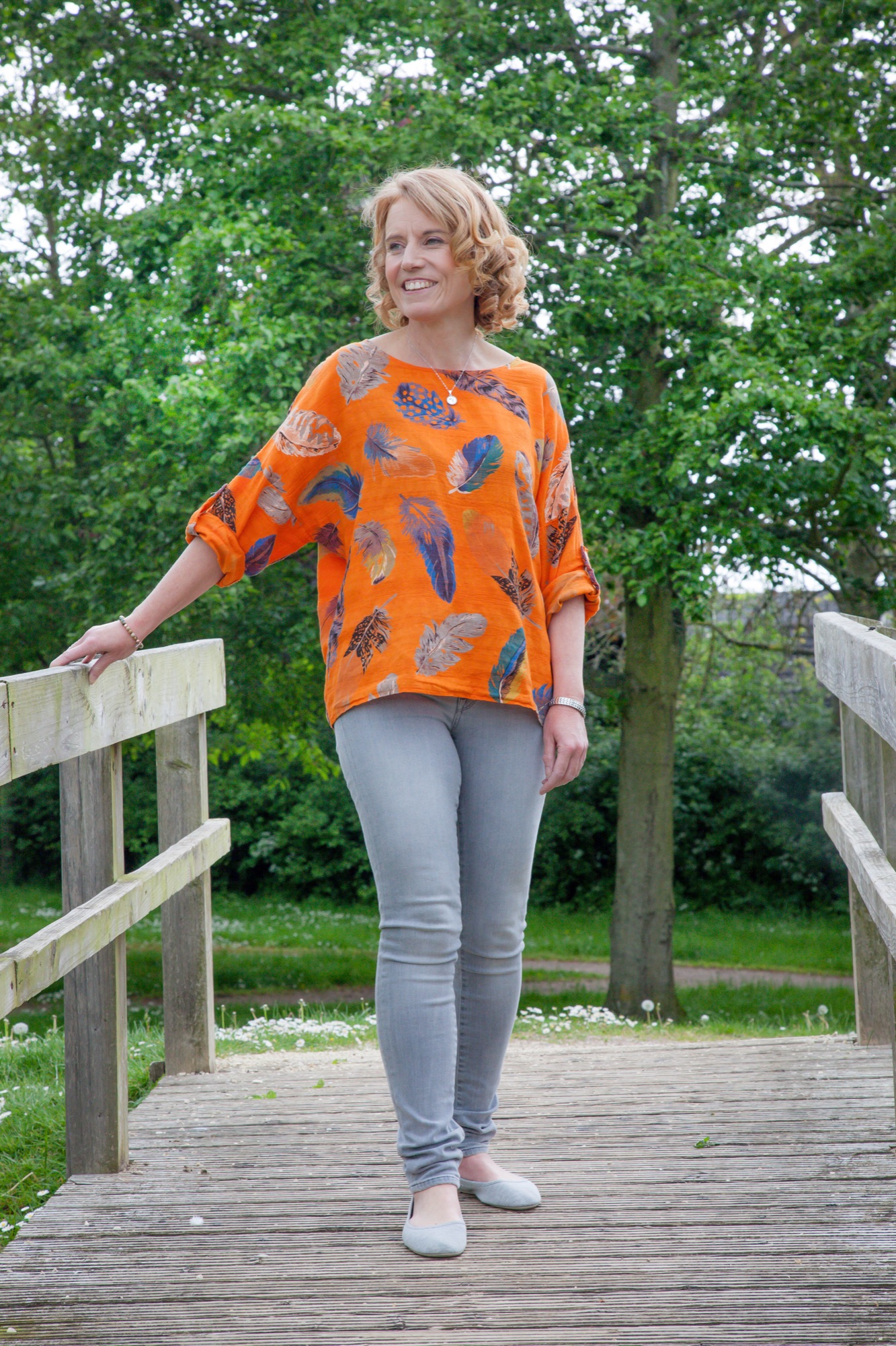 Gina on a bridge surrounded by trees