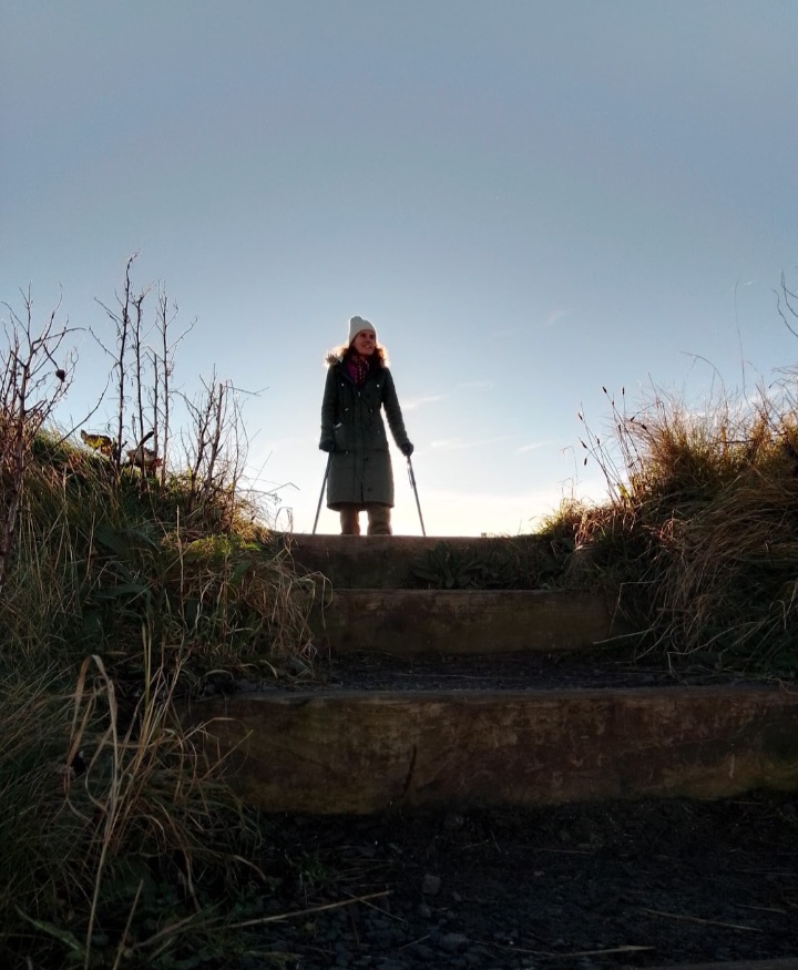 Gina at the top of a set of steps at first light